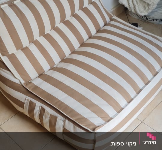 ספה מפוספסת בצבעים חום ולבן על רצפת קרמיקה